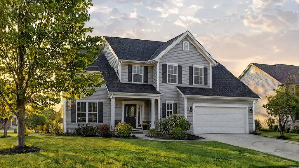 Two-story house with a dark shingle roof, light siding, and a front porch