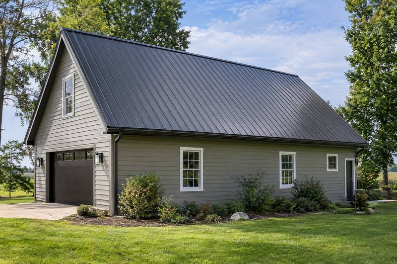 Standing-seam metal roof on a house with light siding